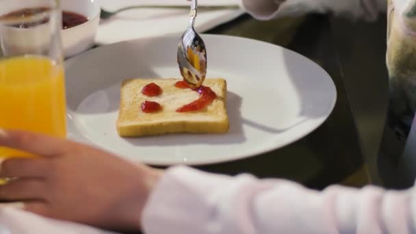 Child Spreads Sweet Jam Toasted Bread Making Smiley Face Toast — Vídeo de stock