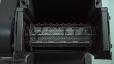 Parça işleme sırasında demir parçaları torbadan düştüğünde yakalanan bir an. Video, metalurji veya mühendislik endüstrisinde tipik bir mekanik işleme gösteriyor.