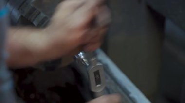 Metal parçalarını torna kullanarak elle kesen bir metal işçisinin yakın çekim görüntüsü. Endüstriyel veya atölyedeki işçilik, kesinlik ve metalciliğin detaylı görüntüleri