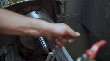 Torna tezgahı kullanarak metal bir bileşenin ipliklerini kesen yetenekli bir işçi. Video, geleneksel teknikler, hassas denetim ve manuel makine operasyonlarında kullanılan zanaatkarlığı vurguluyor