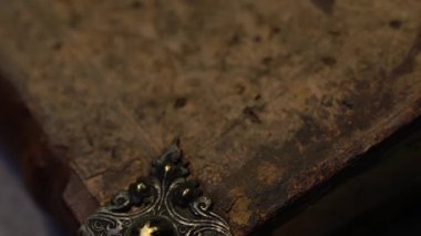 Antika kitap kapağı çatlak ve tozlu, içinde metal süsler var. Yavaş makro tava. Tarihi, eğitici veya arşiv projelerine uygundur