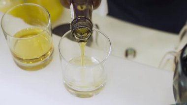 Bir barmen bardaki bardağa dikkatlice viski döker. Altın içeceğe yakın çekim, zarif alkol sunumu, gece atmosferi barda veya restoranda