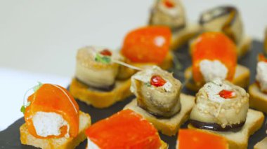 Suşi, somon, kırmızı havyar ve sebzeli kanepeler. Enfes Japon mutfağı ve aperatifleri arka planda yakın plan.