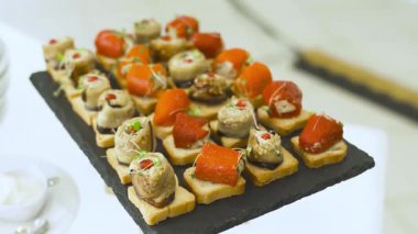 Suşi, somon, kırmızı havyar ve sebzeli kanepeler. Enfes Japon mutfağı ve aperatifleri arka planda yakın plan.