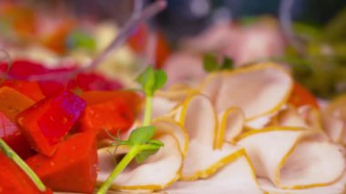 Pastırma dilimleri, kiraz domatesleri, dolmalık biberler ve açık büfe masasında yeşillikler. Ziyafet ya da parti için nefis servis.