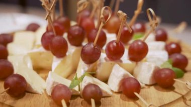 Şiş üzerinde peynir ve üzümden yapılmış nefis kanepeler, ahşap bir tahtanın üzerinde servis edilir. Yemek, açık büfe, düğün ya da parti aperatifleri için mükemmel bir fikir.