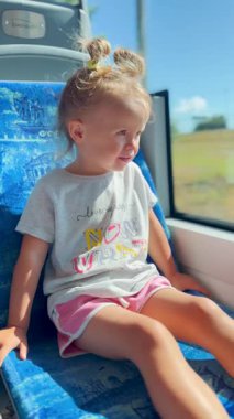 Küçük kız tramvay penceresinden hayranlıkla bakıyor, yolculuğu büyülü bir macera olarak görüyor. Çocukluk ve merakın atmosferi