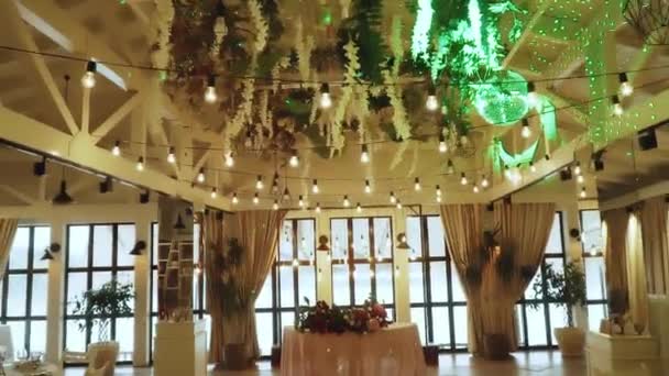 新鮮な花 ランプ 白い家具の遅い動きで結婚パーティーのために装飾された峡谷バンケットホールに沿って戻る動き高品質のフルHd映像 — ストック動画