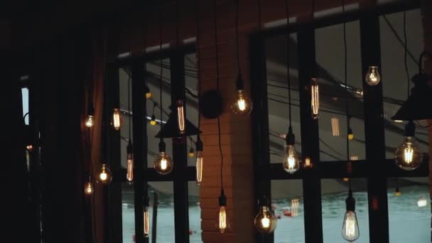 大きな窓の近くの天井には 内部のランプを失う ロフトカフェの美しいランプ ロフトスタイルの美しい装飾 スローモーション 高品質のフルHd映像 — ストック動画