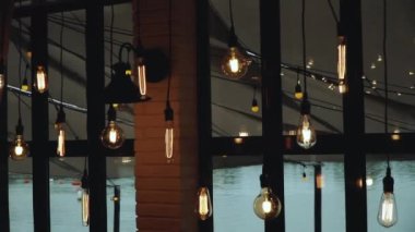 Tavandaki iç lamba büyük pencerenin yanında. Çatı katındaki güzel lamba, tavan arası tarzı güzel dekorasyon, yavaş çekim. Yüksek kaliteli FullHD görüntüler