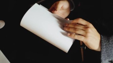Erkek eli beyaz kağıda, tahta masaya mektup yazar. Düğün hazırlıkları. Sevgi dolu sözler. Yakın plan. Yüksek kalite FullHD görüntüler.