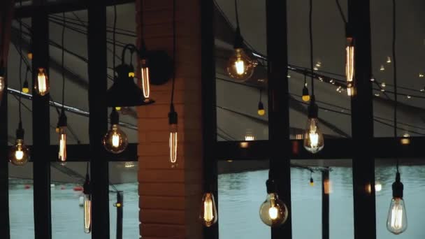 大きな窓の近くの天井の内部ランプ ロフトカフェの美しいランプ ロフトスタイルの美しい装飾 スローモーション 高品質のフルHd映像 — ストック動画