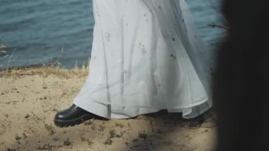 Elbiseli kız deniz fenerinin yakın çekiminde rüzgârda gelişiyor. Yüksek kalite 4k görüntü