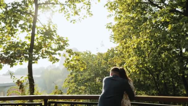 Молодая Прекрасная Пара Находясь Рядом Перилами Осеннего Парка Обнимается Наслаждается — стоковое видео