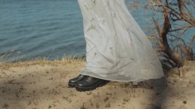 the girl in the dress, the dress develops in the wind at the lighthouse close-up shot. High quality 4k footage