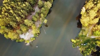Gölün ortasında çam ağaçları olan küçük bir adanın havadan görünüşü. Adanın yakın çekim görüntüsü. 4k görüntü
