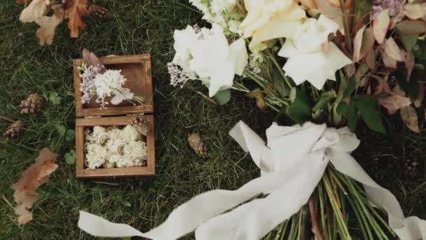 結婚指輪だ 緑の芝生の上に木製のボックスに結婚指輪の花で飾られ スローモーション 高品質のフルHd映像 — ストック動画