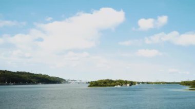 Güzel Dnipro nehri şehirde yeşil ve taze bitki örtüsüyle çevrili, gökyüzünde beyaz bulutlar, ağır çekim. Yüksek kaliteli FullHD görüntüler