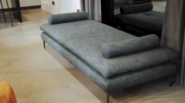 Bekleme salonunun içinde aynanın yanında gri kanepe var. İç kısmı tavan arası tarzı, yavaş çekim. Yüksek kalite 4k görüntü