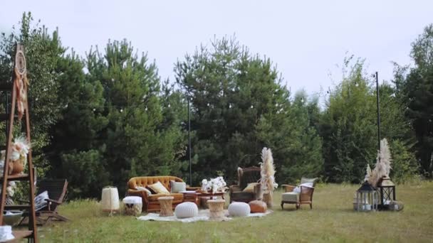 結婚式でリラックスするための装飾されたエリア レトロなテーブルと美しい花束それの上に枕と茶色のアンティークのソファ スローモーション 高品質4K映像 — ストック動画