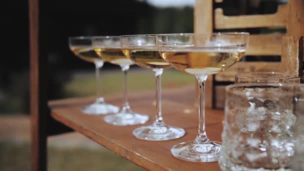 慢动作地在香槟酒杯中倒入闪闪发光的葡萄酒 提供自助餐和四杯香槟 高质量的4K镜头 — 图库视频影像