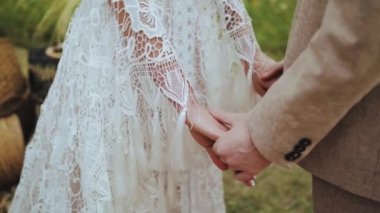 Gelin ve Damat Boho usulü düğün töreninde el ele tutuşuyor. Yakın plan el ele tutuşmalar, yavaş çekim. Yüksek kalite 4k görüntü