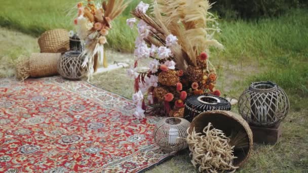 户外婚礼上的特写漂亮的Boho拱形装饰 色彩艳丽的花卉组合 木椅和老式地毯 夏天的婚礼高质量的 — 图库视频影像