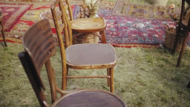木製の椅子や昔ながらのカーペット 屋外結婚式の美しい装飾のクローズアップ 夏の結婚式スローモーション 高品質4K映像 — ストック動画
