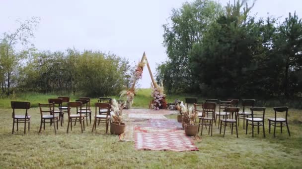 户外婚礼上漂亮的波希米亚拱形装饰 花柱色 木椅和老式地毯组成的花卉组合 夏天的婚礼高质量4K — 图库视频影像