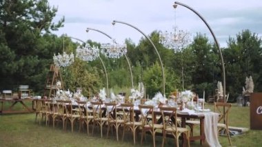 Boho tarzı düğün yemeği, tabak ve şarap bardakları için mum ve kurutulmuş pastel çiçeklerle servis edilen masa. Yüksek kalite 4k görüntü