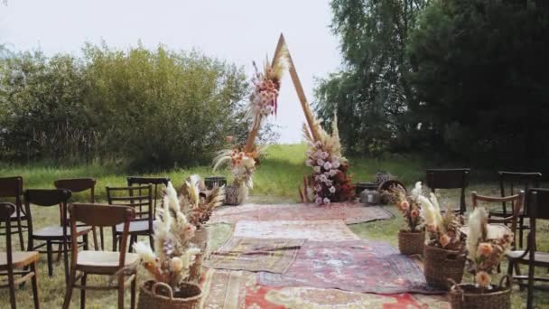 户外婚礼上漂亮的波希米亚拱形装饰 花柱色 木椅和老式地毯组成的花卉组合 夏天的婚礼高质量4K — 图库视频影像