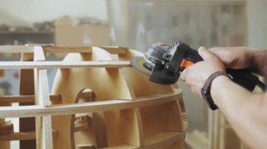 A professional carpenter working with wood on a woodworking machine grinds and polishes wood. Handmade furniture. Manufactures furniture parts in natural light. Slow motion. Carpentry tools.4k