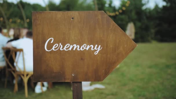 素朴な結婚式の装飾 碑文の儀式と木製のプラーク 芝生のプレートの緑の背景に儀式 結婚式の装飾スローモーション 高品質4K映像 — ストック動画