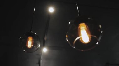 İzole edilmiş karanlık odada abajur ve klasik ampul. Yakın çekim ve yavaş çekim. Eski çatı katı lambaları. Yüksek kalite 4k görüntü
