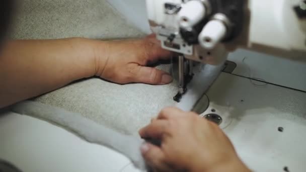 女人用缝纫机手工缝制面料 这台机器在灰色的织物上缝合线 动作缓慢 高质量的4K镜头 — 图库视频影像