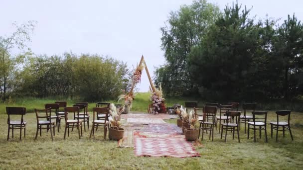 屋外結婚式の美しいアーチ装飾 パステルカラー ドライフラワー 木製の椅子や昔ながらのカーペットの花の組成物 夏の結婚式 高品質4K映像 — ストック動画