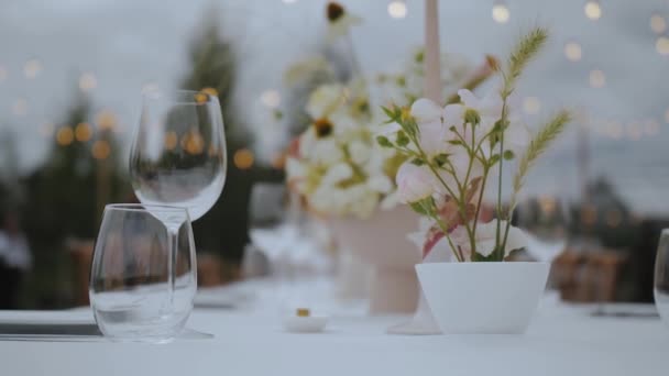 小さな居心地の良い結婚式パーティーでパステル野生の花やスパイクレットとお祝いの結婚式のテーブル設定のクローズアップ スローモーション 高品質4K映像 — ストック動画