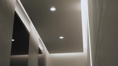 Minimalist iç mekanlı yuvarlak modern tavan lambası ve gizli LED arka lambası. Işıklandırma ekipmanlarıyla minimal iç mekan. Modern lamba. Şatafatlı Avize, ağır çekimde çekilen çekimler.