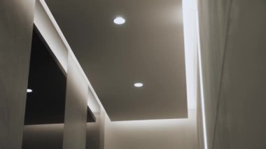 Minimalist iç mekanlı yuvarlak modern tavan lambası ve gizli LED arka lambası. Işıklandırma ekipmanlarıyla minimal iç mekan. Modern lamba. Şatafatlı Avize, ağır çekimde çekilen çekimler.