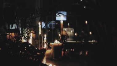Birçok güzel mum karanlık bir odada yanar. Güzel ışıklandırma, düğün dekorasyonları, romantik atmosfer, yavaş çekim. - Evet. Yüksek kalite 4k görüntü
