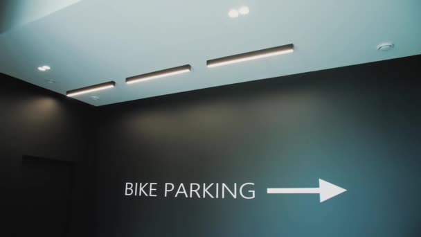 建物内の碑文自転車駐車場 緑の背景に自転車の駐車標識 スローモーション 高品質4K映像 — ストック動画