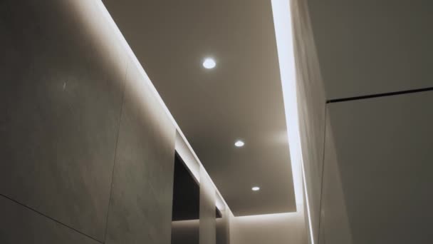 隠されたLedバックライトとミニマリストインテリアのラウンド現代的な天井ランプ 照明機器とミニマリストインテリア 現代的なランプ 高級シャンデリア スローモーション 4K映像 — ストック動画