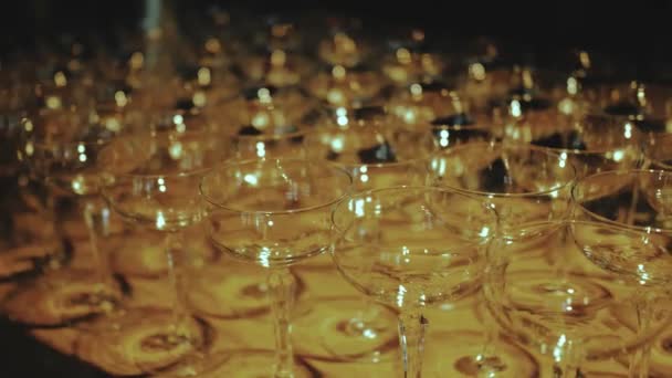 许多空香槟酒杯的多利镜头留在桌上 温暖的灯光洒落在玻璃杯上 慢动作 高质量的4K镜头 — 图库视频影像