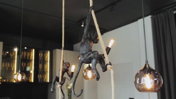 装飾的なモダンなデザインの猿のスタイルのランプのドリーショットは ロフトのインテリアの天井から掛けます インテリア照明 ラウンドガラスボールシャンデリア 透明と黄金の色 スローモーションショット — ストック動画