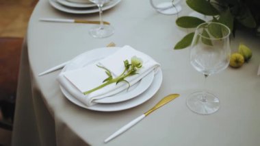 Top view of beautiful wedding decor, all decorated in white, green colors style. Classic served plates and golden forks on the table. camera moving slow motion. . High quality 4k footage