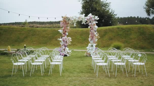 Ślub Ozdobiony Łuk Kwiatów Pastelowych Kolorach Białe Krzesła Przed Łukiem — Wideo stockowe