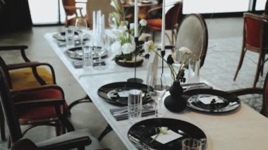 Düğün dekoru, hepsi siyah ve beyaz renklerle süslenmiş, şenlikli bir masa resmi. Üzerinde yumuşak çiçek olan güzel siyah tabaklar, mum, masa 45 'liğinin üzerindeki şarap kadehleri.