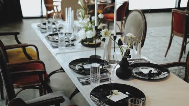 婚纱装饰 全部为黑白色彩 装饰华丽的节日餐桌 漂亮的黑色盘子 桌上有娇嫩的花朵 4K镜头 — 图库视频影像