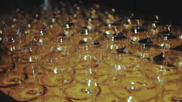 许多空香槟酒杯的中空镜头一直放在桌上 温暖的灯光洒落在玻璃杯上 慢动作 高质量的4K镜头 — 图库视频影像