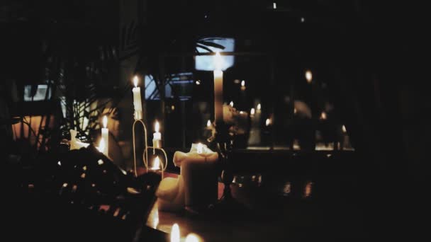 许多蜡烛在木制桌子上燃烧着 在黑暗的氛围中 室内餐厅里 只有蜡烛点着 钢琴上点着蜡烛 动作缓慢 高质量的4K镜头 — 图库视频影像